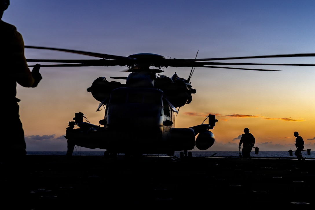 U.S. Sailors with San-Antonio-class amphibious transport dock USS San Antonio (LPD 17) place chocks and chains on a CH-53E Super Stallion helicopter with Marine Medium Tiltrotor Squadron (VMM) 263 (Reinforced), 22nd Marine Expeditionary Unit (Special Operations Capable), during flight operations, aboard San Antonio while underway in the Caribbean Sea, March 28, 2025. U.S. military forces are deployed to the Caribbean in support of the U.S. Southern Command mission, Department of War-directed operations, and the president’s priorities to disrupt illicit drug trafficking and protect the homeland. (U.S. Marine Corps photo)