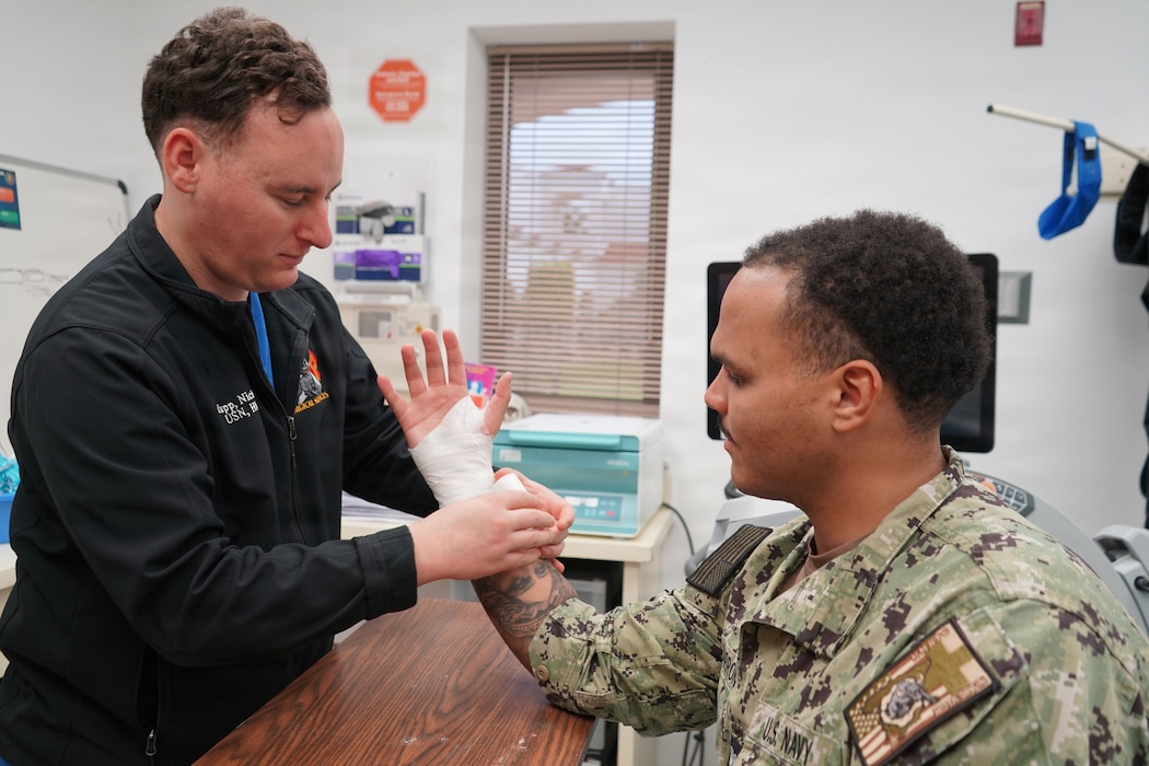 260201-N-FT324-9618. ROTA, Spain (February 1, 2026). Hospital Corpsman 2nd Class Nicholas Krupp, a native of Laplace, Louisiana, assigned to Navy Medicine Readiness and Training Command Rota, applies a supportive wrap to a Sailor’s wrist during an orthopedic clinic appointment. Krupp serves as an orthopedic technician, providing specialized musculoskeletal care to active duty service members, retirees and beneficiaries in support of injury treatment, recovery and operational readiness. (U.S. Navy photo by Lt. Cmdr. Alicia Sacks)