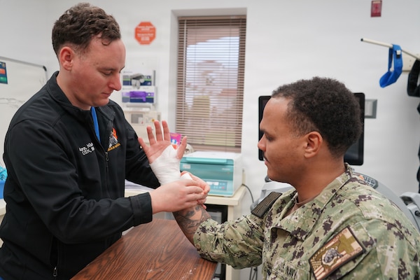 260201-N-FT324-9618. ROTA, Spain (February 1, 2026). Hospital Corpsman 2nd Class Nicholas Krupp, a native of Laplace, Louisiana, assigned to Navy Medicine Readiness and Training Command Rota, applies a supportive wrap to a Sailor’s wrist during an orthopedic clinic appointment. Krupp serves as an orthopedic technician, providing specialized musculoskeletal care to active duty service members, retirees and beneficiaries in support of injury treatment, recovery and operational readiness. (U.S. Navy photo by Lt. Cmdr. Alicia Sacks)