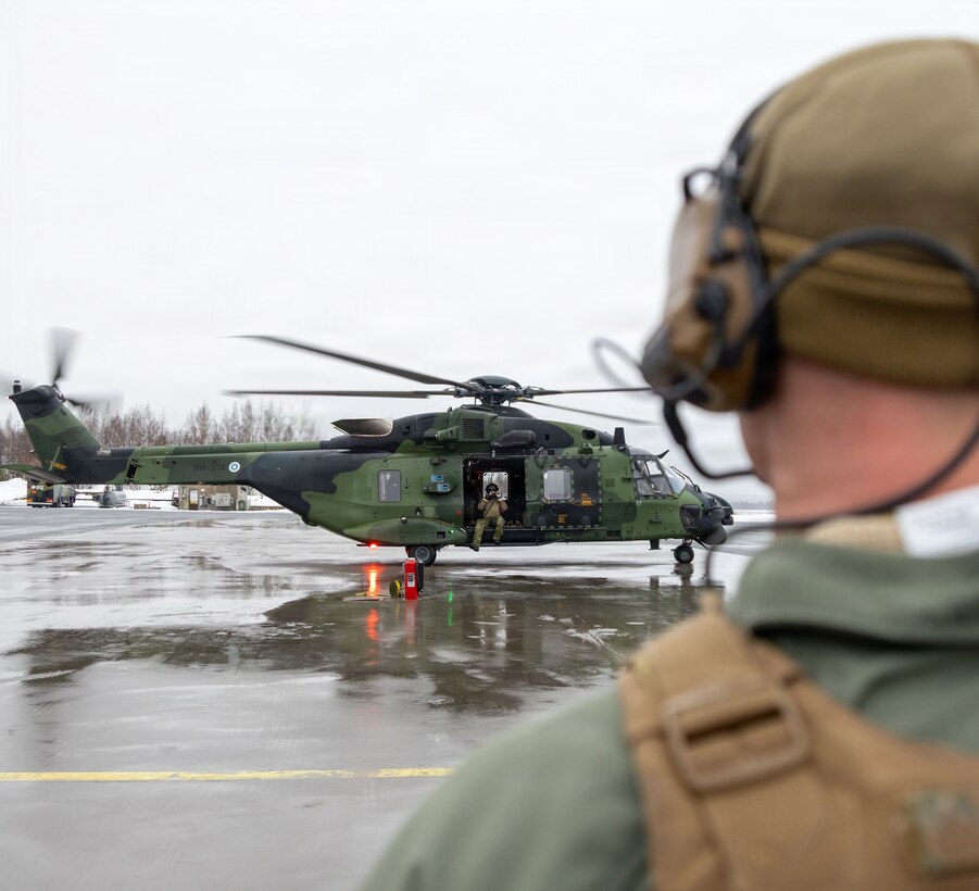 U.S. Marine Corps Sgt. Hunter Bush, an expeditionary fuels technician with Marine Wing Support Squadron (MWSS) 273, Marine Air Control Group 28, 2nd Marine Aircraft Wing, watches Marines refuel a Finnish NH-90 helicopter a forward arming and refueling point at Rovaniemi Air Base, Finland, March 18, 2026. MWSS-273 refueled Finnish helicopters at a FARP to support NATO air operations during exercise Cold Response 26. A key component of NATO's enhanced vigilance activity Arctic Sentry, exercise Cold Response 26 is a Norwegian-led winter military exercise designed to enhance collective defense capabilities and ensure U.S. readiness to rapidly deploy and seamlessly operate alongside NATO Allies in challenging arctic conditions. Bush is a native of Illinois. (U.S. Marine Corps photo by Lance Cpl. Donovan Pimentel)