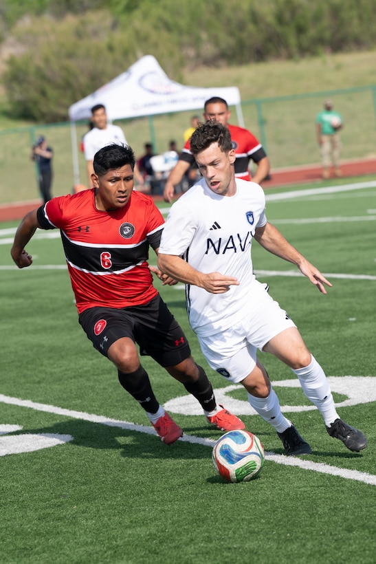 U.S. Navy LT Mitchell Hopkins, assigned to NS Norfolk, VA, and Marine Corps Sgt. Jonathan Montenegro, assigned to Quantico, VA, battle for possesion of the ball during the 2026 Armed Forces Men’s Soccer Championship at Phantom Warrior Stadium on Fort Hood, Texas, Apr. 1, 2026. Service members competed in soccer for championship honors while representing their respective services.