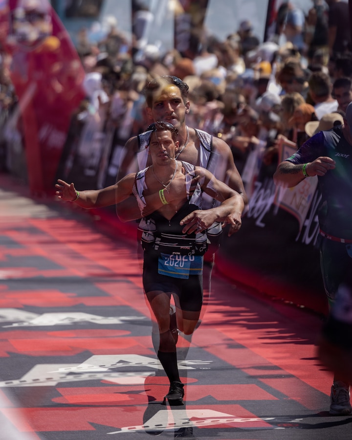 A competitor completes the IRONMAN 70.3 Oceanside race in Oceanside, Calif., March 28, 2026. The race consists of a 1.2-mile swim in Oceanside Harbor, a 56-mile bicycle ride through Marine Corps Base Camp Pendleton and a 13.1-mile run to the Oceanside Pier. The annual event, which travels through a portion of MCB Camp Pendleton, helps the installation maintain strong community relations with the city of Oceanside. (U.S. Marine Corps photo illustration by Sgt Rafael; a double exposure effect was captured in camera by taking two separate images layered on top of the other, with one properly exposing for the foreground and the other exposing for the background.)