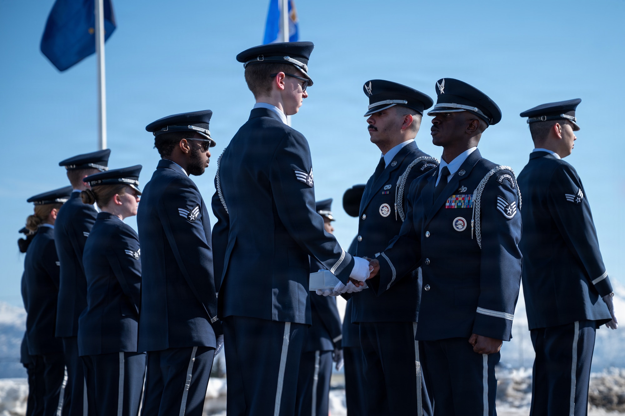 Joint Base Elmendorf-Richardson Honor Guard graduates receive ceremonial badges from U.S. Air Force Staff Sgt. Laban Ongeri, JBER Honor Guard noncommissioned officer in charge, signifying the graduates’ completion of their training course during an honor guard graduation ceremony on JBER, Alaska, March 31, 2026. The Honor Guard is one of the U.S. Air Force’s oldest organizations, serving as a premiere standard of discipline and military professionalism to the public eye.