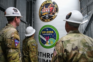 People stand near a rocket.