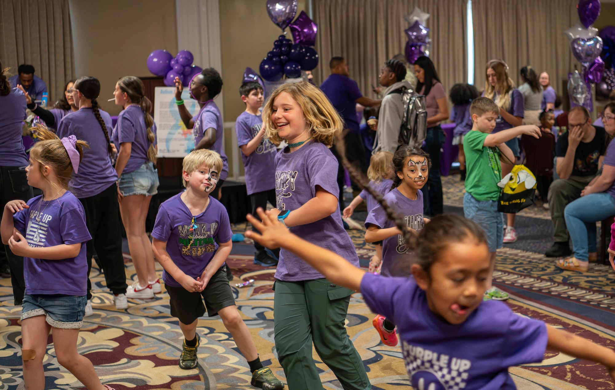 Children in purple shirts running around