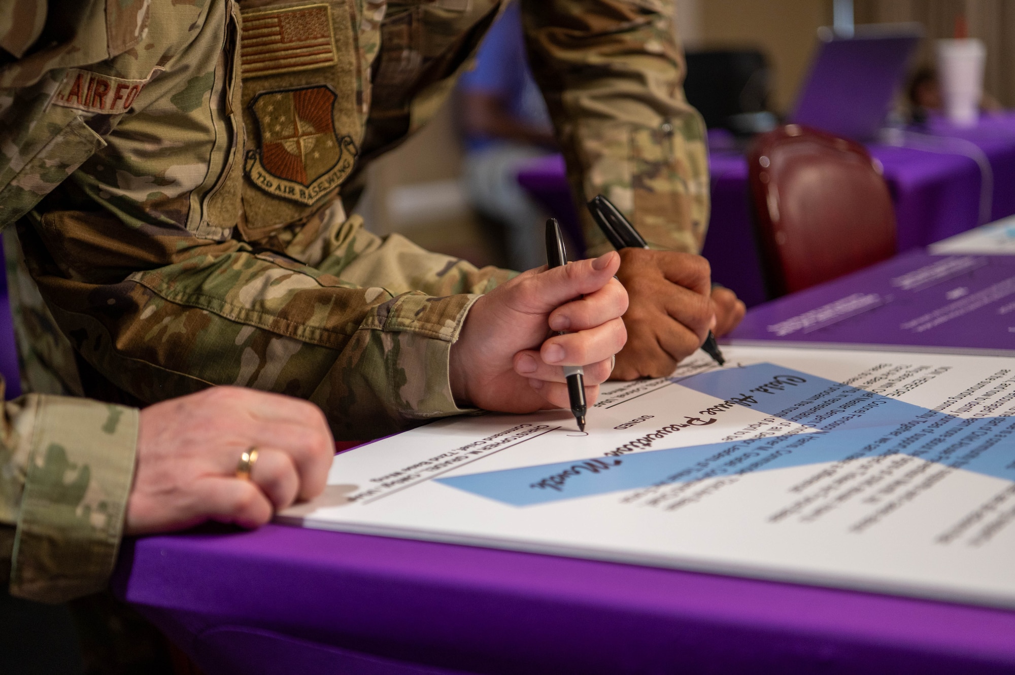 Close up of two hands signing document on table