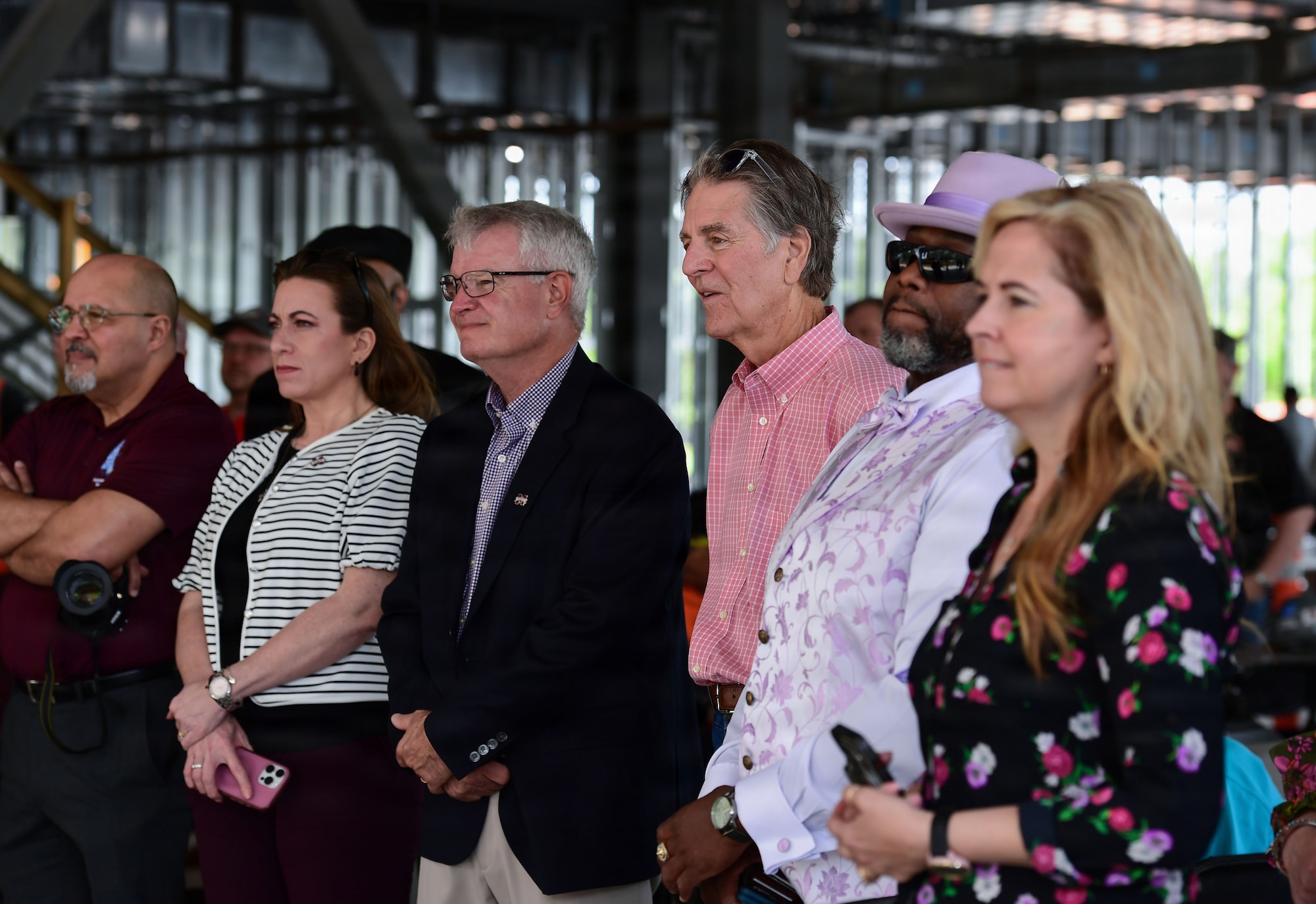 A group of people stand in a group looking ahead.