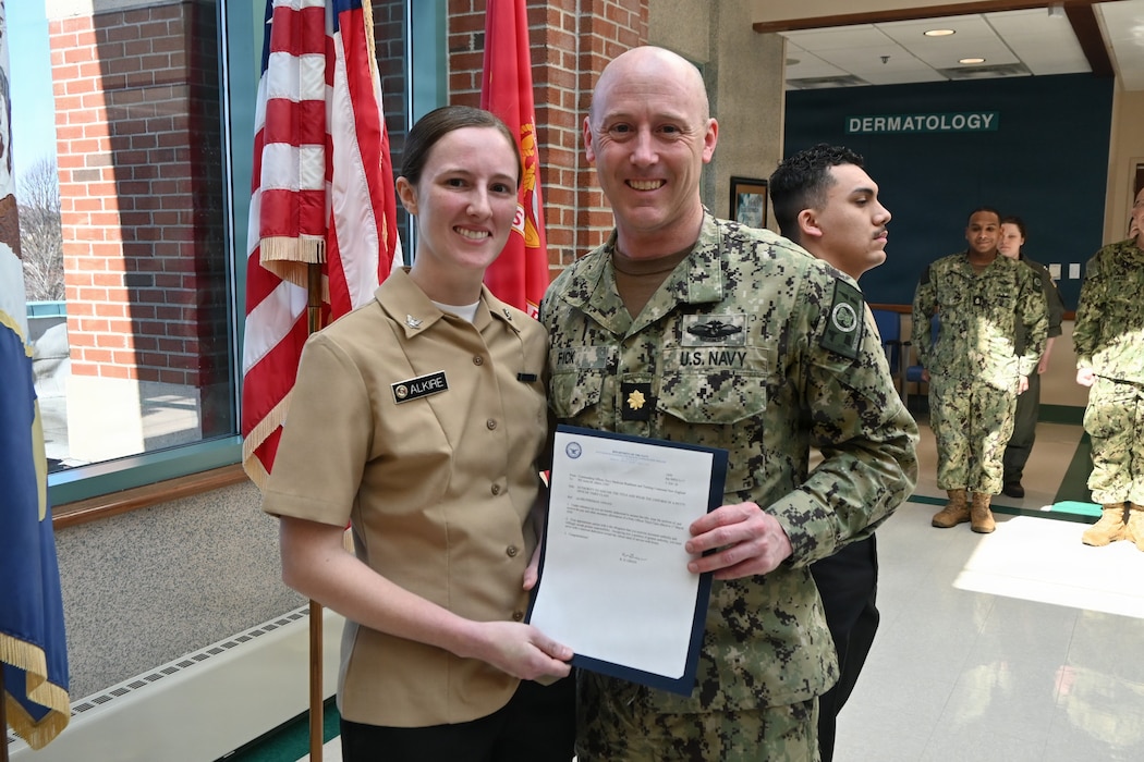 260317-N-OV429-1001 NEWPORT, R.I. (Mar. 17, 2026) Hospital Corpsman 3rd Class Anna Alkire, assigned to Navy Medicine Readiness and Training Command (NMRTC) New England is presented with a frocking letter to the rank of Petty Officer 3rd Class, by Lt. Cmdr. Ryan Fick, division officer, medical readiness clinic, during a promotion ceremony held at Naval Health Clinic New England, Newport, R.I., Mar. 10, 2026. NMRTC New England provides operational training to healthcare professionals through healthcare delivery to optimize both medical staff and Warfighter and readiness. (U.S. Navy photo by Lieutenant Sydney Wall)