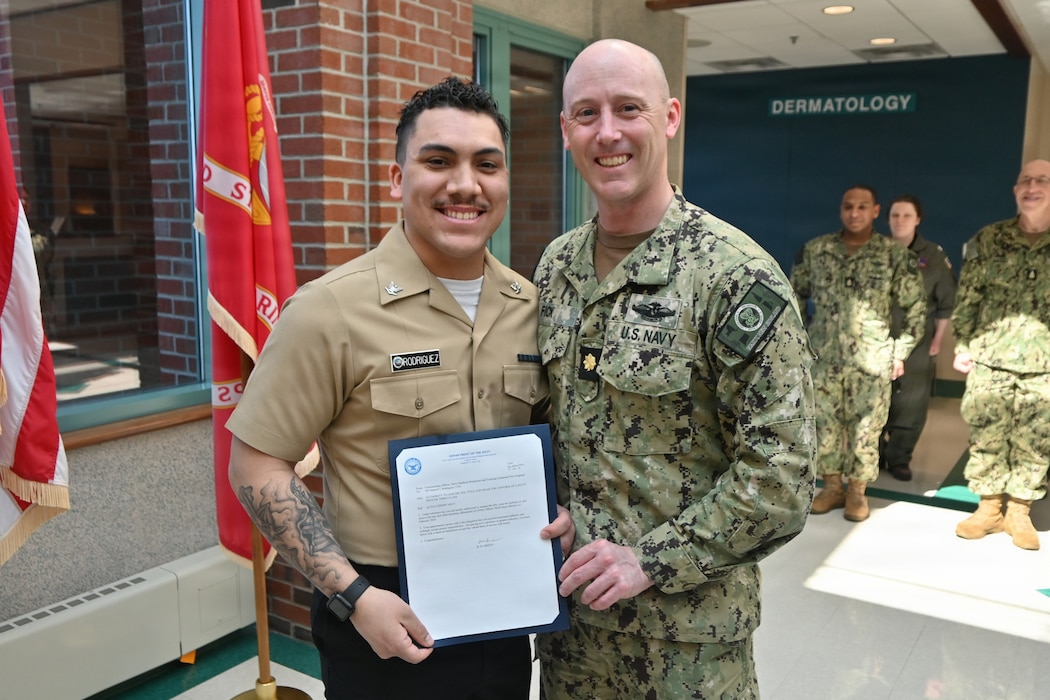 260317-N-OV429-1001 NEWPORT, R.I. (Mar. 17, 2026) Hospital Corpsman Third Class Samuel Rodriguez, assigned to Navy Medicine Readiness and Training Command (NMRTC) New England is presented with a frocking letter to the rank of Petty Officer 3rd Class, by Lt. Cmdr. Ryan Fick, division officer, medical readiness clinic, during a promotion ceremony held at Naval Health Clinic New England, Newport, R.I., Mar. 10, 2026. NMRTC New England provides operational training to healthcare professionals through healthcare delivery to optimize both medical staff and Warfighter and readiness. (U.S. Navy photo by Lieutenant Sydney Wall)