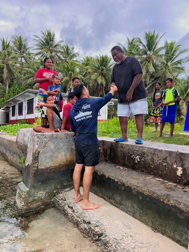 Lt. Ray Cerrato, commanding officer of USCGC Oliver Henry (WPC 1140), greets the leaders and residents of Kuttu, Federated States of Micronesia, on March 18, 2026, during a visit to support an FSM government request to deliver supplies and capture imagery of a vessel grounded in 1998. The crew of the USCGC Oliver Henry (WPC 1140) returned to Guam on March 29, 2026, closing out a 29-day patrol period that restored a critical tsunami early warning station to a remote Pacific atoll, delivered humanitarian supplies to two island communities, and enforced fisheries laws across more than 4,000 nautical miles. (U.S. Coast Guard photo)