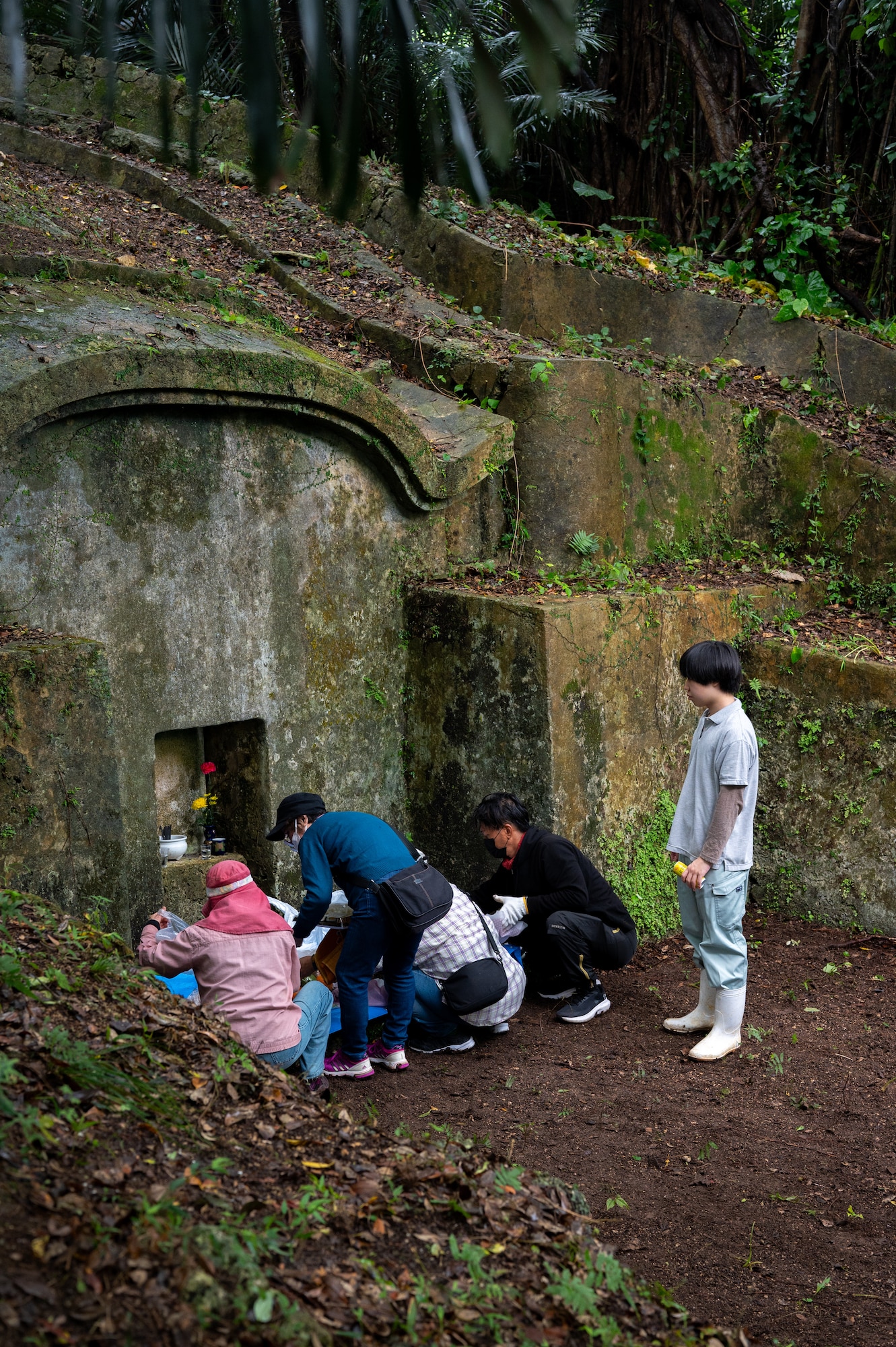 A local Okinawan family places food at an ancestral tomb during Shimi at Kadena Air Base, Japan.