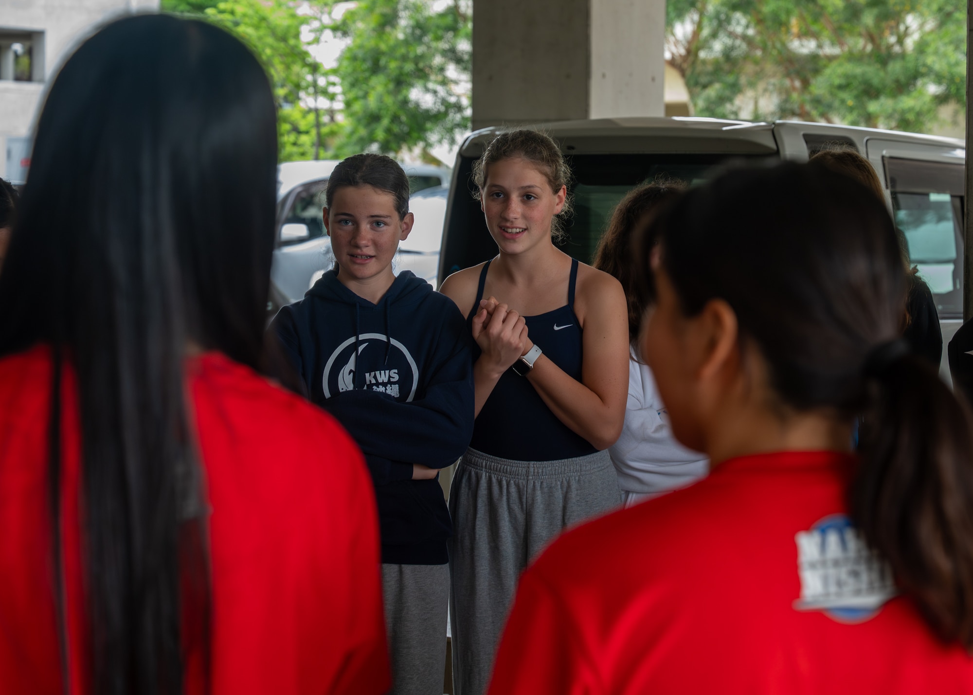 Students stand in a circle while playing an ice breaker game.
