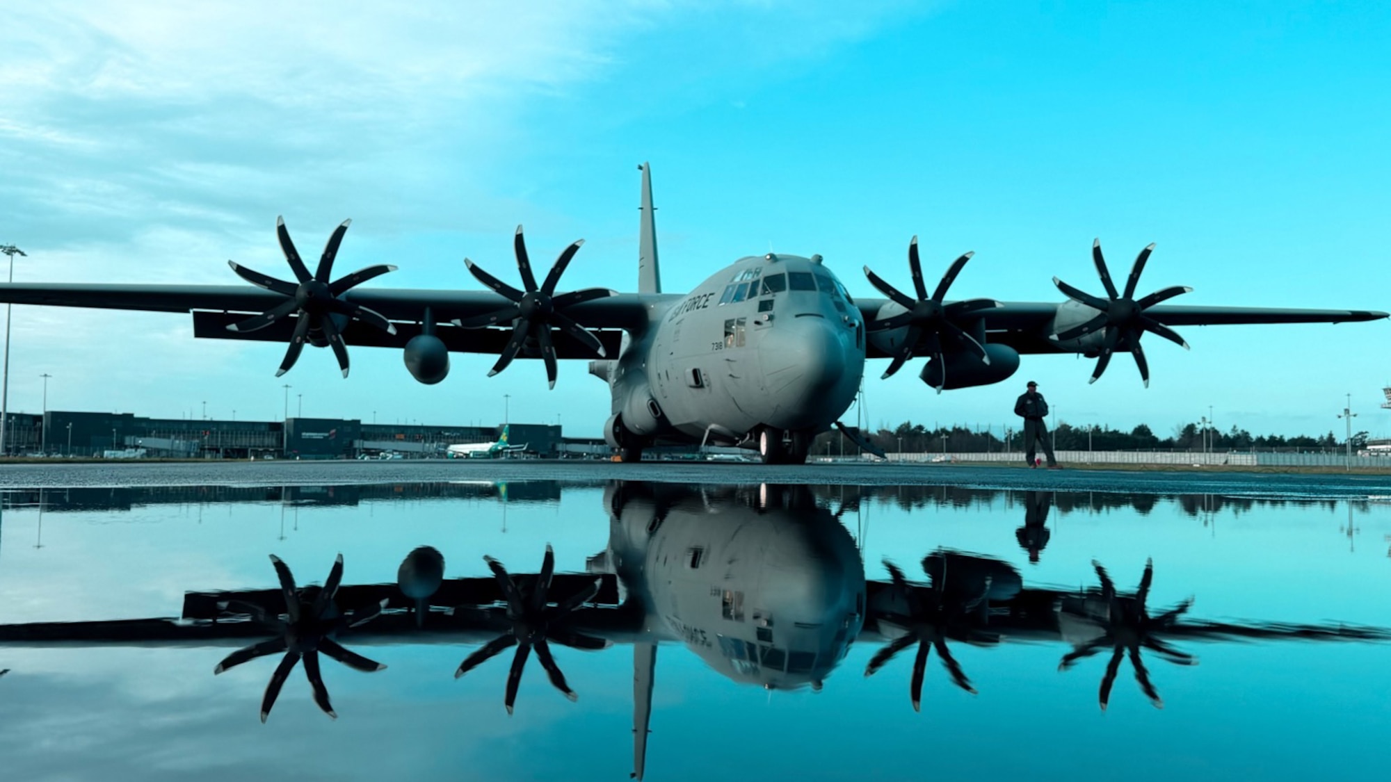A C-130H Hercules aircraft parked on an airfield.
