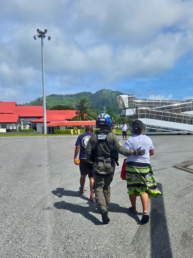 U.S. Coast Guard Petty Officer 3rd Class James Warguez, an aviation maintenance technician assigned to Air Station Barbers Point, escorts members of a local family from a U.S. Coast Guard MH-65 Dolphin helicopter embarked on Legend-class cutter USCGC Midgett (WMSL 757) to reunite with loved ones in Weno, Federated States of Micronesia, on April 6, 2026. The crew of Midgett rescued the family on April 6 after their 23-foot single-outboard skiff vessel went missing a week earlier in the waters of Chuuk State. U.S. Coast Guard missions in the Indo-Pacific focus on issues that directly support and advance our regional partners’ efforts to protect fish stocks and ensure the safety of life at sea, helping to ensure a secure and prosperous Indo-Pacific. (U.S. Coast Guard photo by Lt. Doug Brown)