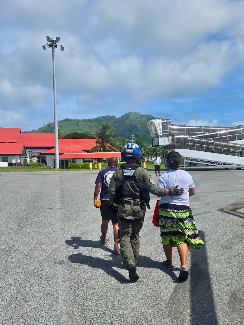 U.S. Coast Guard Petty Officer 3rd Class James Warguez, an aviation maintenance technician assigned to Air Station Barbers Point, escorts members of a local family from a U.S. Coast Guard MH-65 Dolphin helicopter embarked on Legend-class cutter USCGC Midgett (WMSL 757) to reunite with loved ones in Weno, Federated States of Micronesia, on April 6, 2026. The crew of Midgett rescued the family on April 6 after their 23-foot single-outboard skiff vessel went missing a week earlier in the waters of Chuuk State. U.S. Coast Guard missions in the Indo-Pacific focus on issues that directly support and advance our regional partners’ efforts to protect fish stocks and ensure the safety of life at sea, helping to ensure a secure and prosperous Indo-Pacific. (U.S. Coast Guard photo by Lt. Doug Brown)