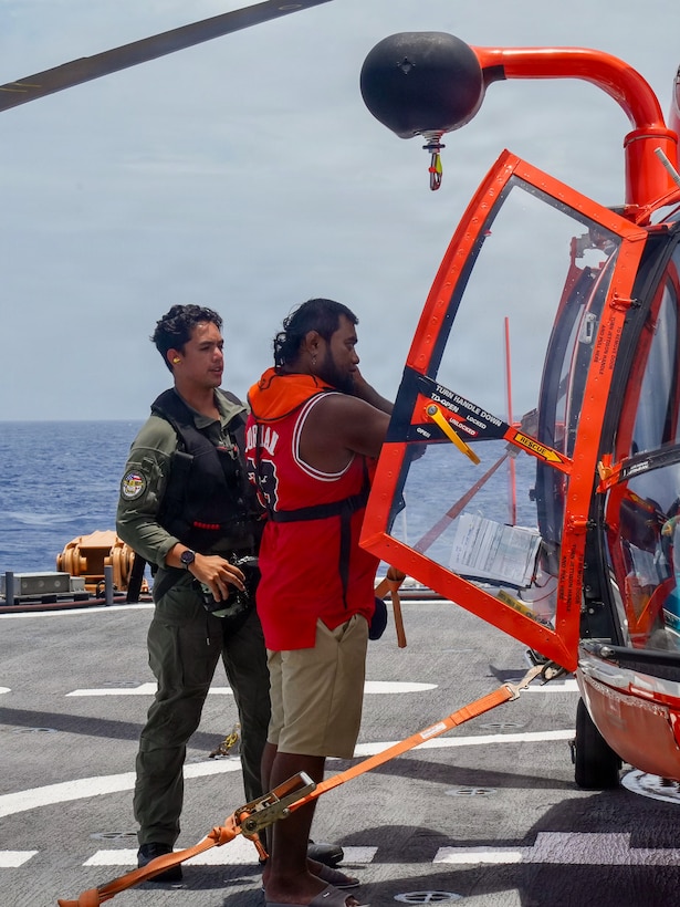 U.S. Coast Guard Petty Officer 3rd Class James Warguez, an aviation maintenance technician assigned to Air Station Barbers Point, escorts a member of a local family to a U.S. Coast Guard MH-65 Dolphin helicopter embarked on Legend-class cutter USCGC Midgett (WMSL 757) for further transport to Weno, Federated States of Micronesia, on April 6, 2026. The crew of Midgett rescued the family on April 6 after their 23-foot single-outboard skiff vessel went missing a week earlier in the waters of Chuuk State. U.S. Coast Guard missions in the Indo-Pacific focus on issues that directly support and advance our regional partners’ efforts to protect fish stocks and ensure the safety of life at sea, helping to ensure a secure and prosperous Indo-Pacific. (U.S. Coast Guard photo by Petty Officer 3rd Class Jennifer Nilson)