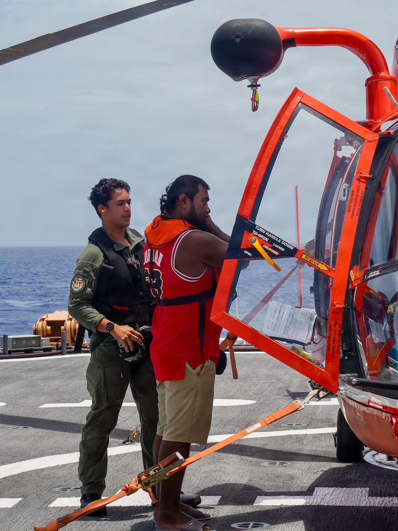U.S. Coast Guard Petty Officer 3rd Class James Warguez, an aviation maintenance technician assigned to Air Station Barbers Point, escorts a member of a local family to a U.S. Coast Guard MH-65 Dolphin helicopter embarked on Legend-class cutter USCGC Midgett (WMSL 757) for further transport to Weno, Federated States of Micronesia, on April 6, 2026. The crew of Midgett rescued the family on April 6 after their 23-foot single-outboard skiff vessel went missing a week earlier in the waters of Chuuk State. U.S. Coast Guard missions in the Indo-Pacific focus on issues that directly support and advance our regional partners’ efforts to protect fish stocks and ensure the safety of life at sea, helping to ensure a secure and prosperous Indo-Pacific. (U.S. Coast Guard photo by Petty Officer 3rd Class Jennifer Nilson)