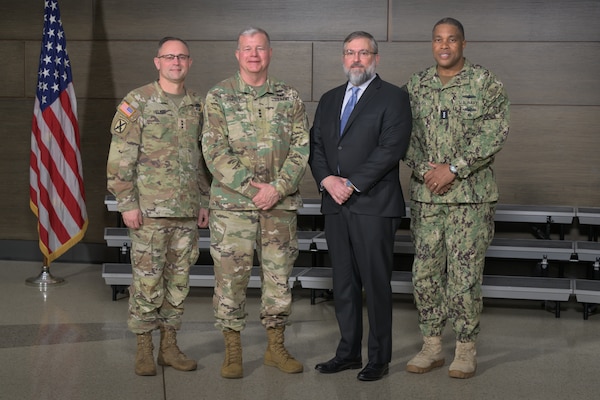 Four men pose for a photo