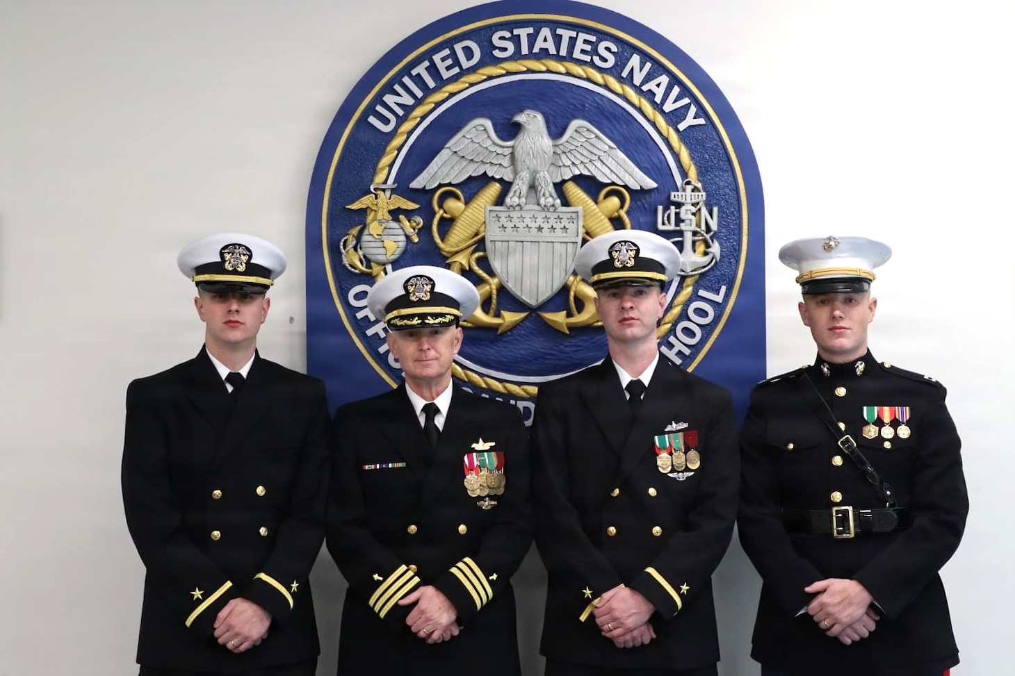 Ensign Samuel Melvin (left), Cmdr. Eric Melvin, Ensign Zachary Melvin, and U.S. Marine Corps Capt. Nathanial Melvin, pose for a photo following a commissioning ceremony at Officer Candidate School (OCS), Newport, Rhode Island. The ceremony marked the commissioning of brothers Samuel and Zachary Melvin as Naval Officers, highlighting a family tradition of service across multiple branches of the armed forces.