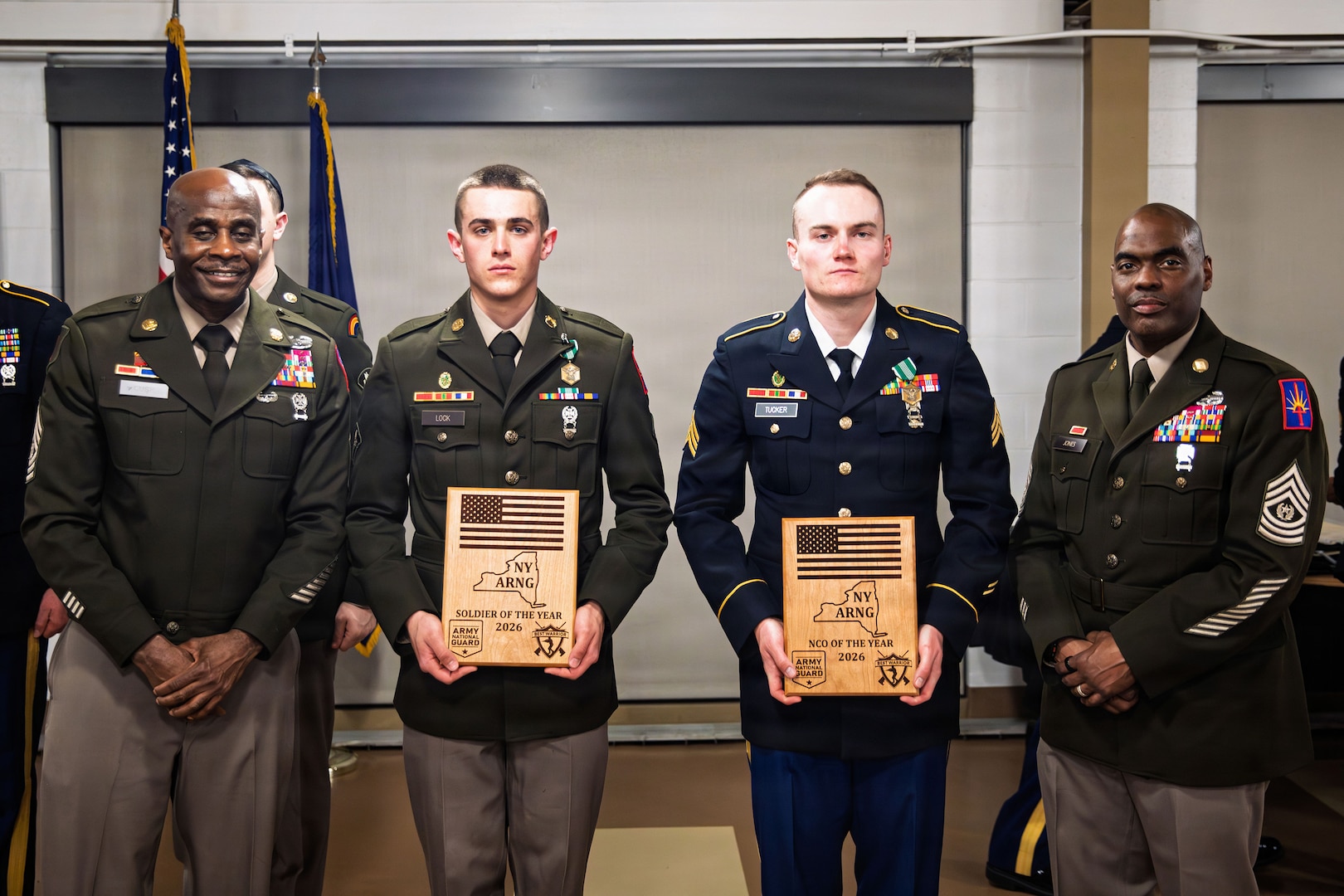 U.S. Army Sgt. Derek Tucker and Spc. Trevor Lock, military police officers with the 105th Military Police Company, 102nd Military Police Battalion, receive gifts for first place at the New York Army National Guard Best Warrior Competition 2026 during an awards ceremony at Camp Smith Training Site, Cortlandt Manor, New York, March 26, 2026.