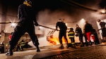 Sailors assigned to Nimitz-class aircraft carrier USS George Washington (CVN 73) combat a fire during an aircraft firefighting class at Surface Warfare School Command (SWSC) on Commander, Fleet Activities Yokosuka, March 14, 2025. SWSC familiarizes Sailors with basic chemistry and classification of fires, firefighting, protective equipment, and procedures for shipboard firefighting using simulated emergency firefighting conditions afloat and ashore.