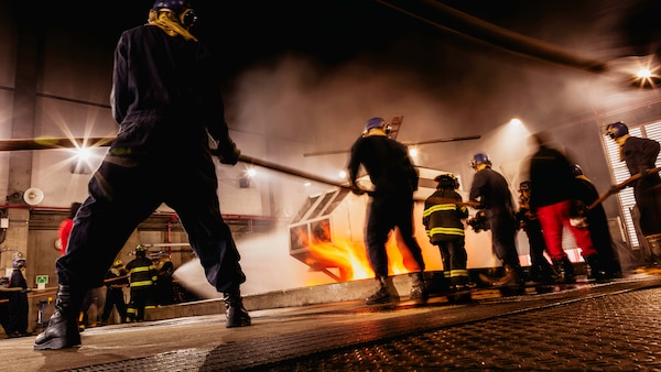 Sailors assigned to Nimitz-class aircraft carrier USS George Washington (CVN 73) combat a fire during an aircraft firefighting class at Surface Warfare School Command (SWSC) on Commander, Fleet Activities Yokosuka, March 14, 2025. SWSC familiarizes Sailors with basic chemistry and classification of fires, firefighting, protective equipment, and procedures for shipboard firefighting using simulated emergency firefighting conditions afloat and ashore.