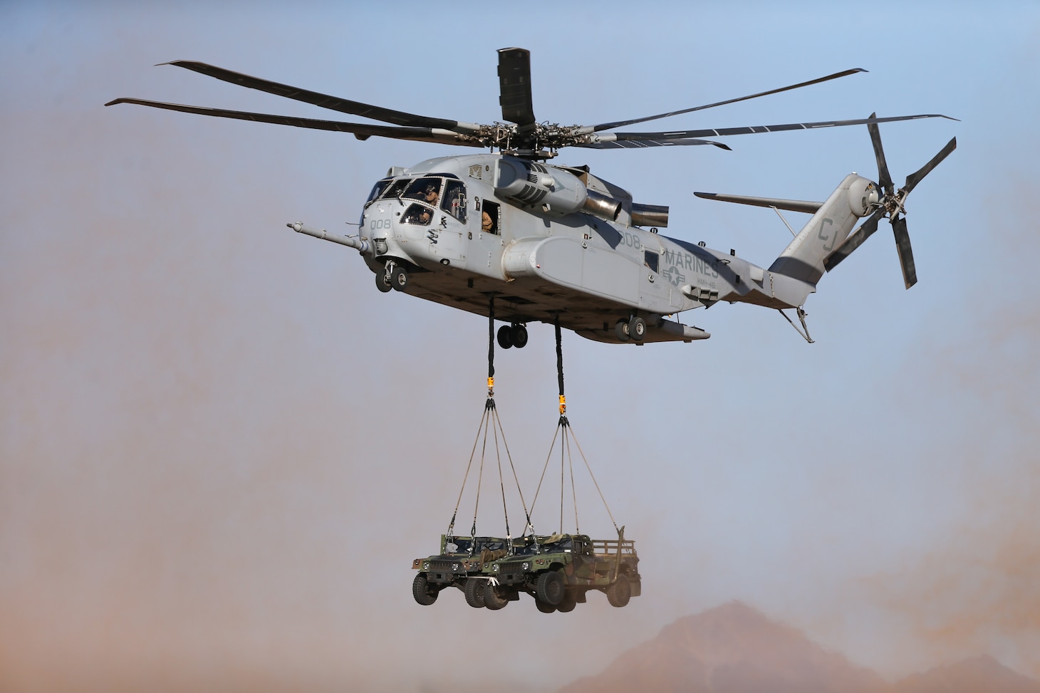U.S. Marine Corps CH-53K King Stallion helicopter assigned to Marine Heavy Helicopter Squadron (HMH) 461, 2nd Marine Aircraft Wing, executes an external lift of two High Mobility Multipurpose Wheeled Vehicles during Weapons and Tactics Instructor (WTI) course 2-23 at Auxiliary Airfield II near Yuma, Arizona, March 28, 2023. WTI is a seven-week training event hosted by MAWTS-1, providing standardized advanced tactical training and readiness, and assists in developing and employing aviation weapons and tactics.