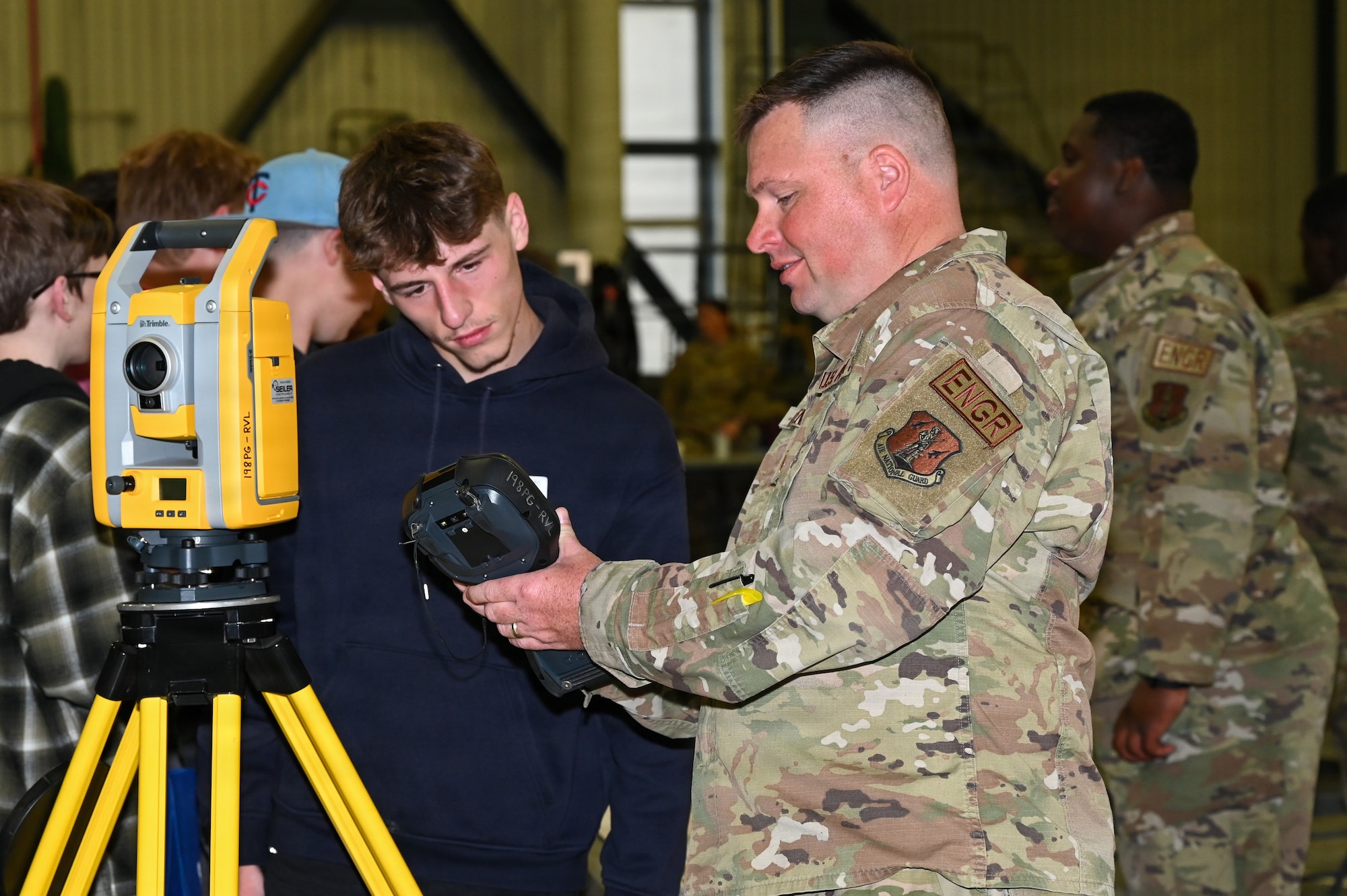 Master Sergeant Daniel Cadenbach, 155th Civil Engineer Squadron engineering assistant, demonstrates surveying equipment to a student during the 155th Air Refueling Wing’s Open Hangar, April 1, 2026, at the Nebraska National Guard air base in Lincoln, Nebraska. Students talked with professionals from around the Air National Guard from over 45 specialties during the event. (U.S. Air National Guard photo by Tech. Sgt. Phil Cowen)