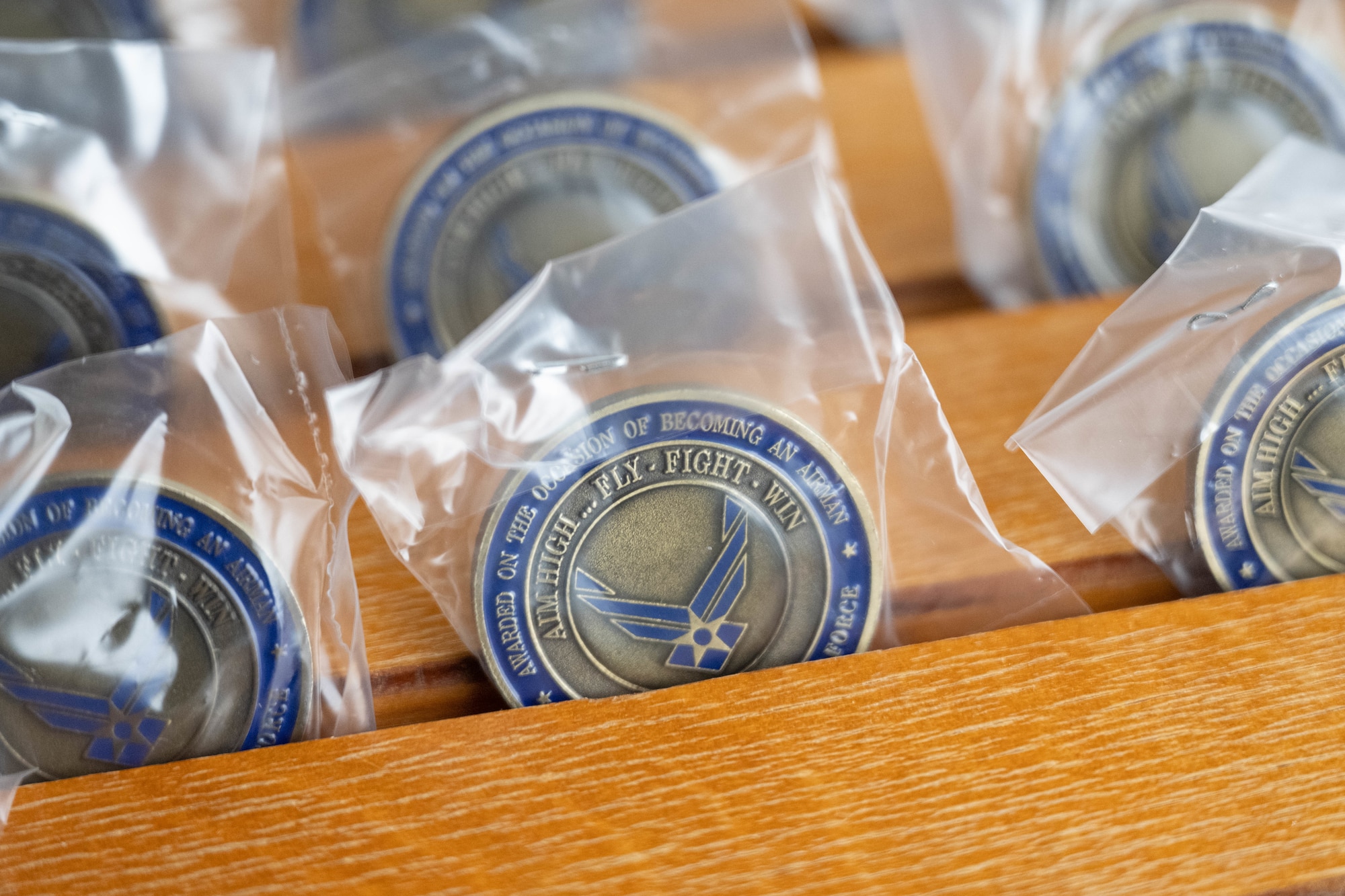An Airman’s Coin is displayed at Joint Base San Antonio-Lackland, Texas, April 1, 2026. During the Coin and Retreat Ceremony, trainees receive their Airman’s Coin, signifying their official transition from trainee to graduate. (U.S. Air Force photo by Airman 1st Class Emma Wright)