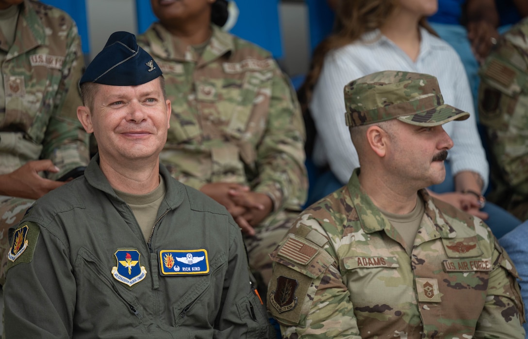 U.S. Air Force Col. Richard Kind, 97th Air Mobility Wing (AMW) commander, left, and Chief Master Sgt. Jonny Adams, 97th AMW command chief, right, watch the Coin and Retreat Ceremony, one out of three events included in Basic Military Training graduation at Joint Base San Antonio-Lackland, Texas, April 1, 2026. The visit to the 37th Training Wing gave Altus leaders the opportunity to not only witness the resilience and professionalism of new Airmen, but also to strengthen the bond between training and operational units. (U.S. Air Force photo by Airman 1st Class Emma Wright)