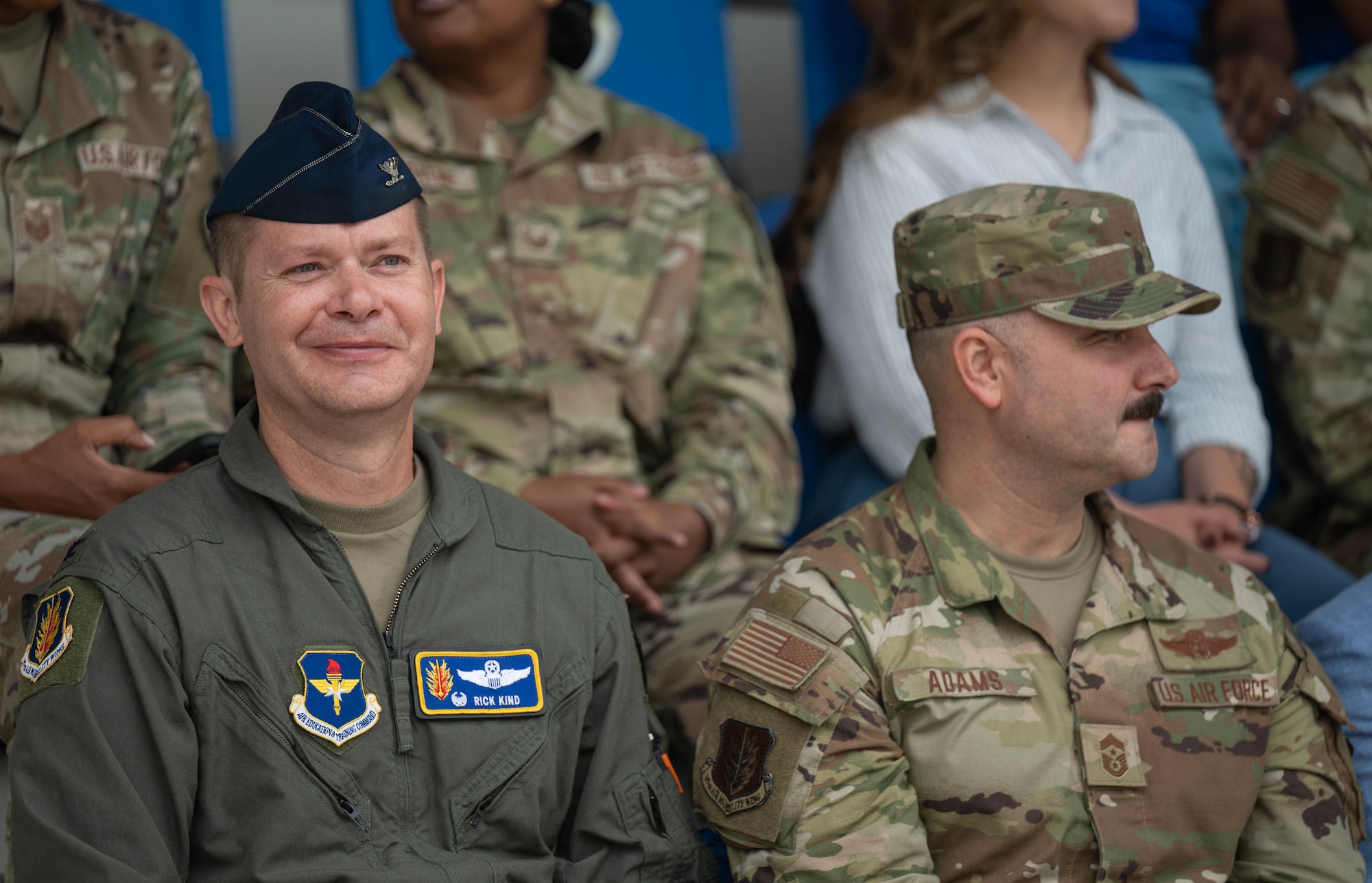 U.S. Air Force Col. Richard Kind, 97th Air Mobility Wing (AMW) commander, left, and Chief Master Sgt. Jonny Adams, 97th AMW command chief, right, watch the Coin and Retreat Ceremony, one out of three events included in Basic Military Training graduation at Joint Base San Antonio-Lackland, Texas, April 1, 2026. The visit to the 37th Training Wing gave Altus leaders the opportunity to not only witness the resilience and professionalism of new Airmen, but also to strengthen the bond between training and operational units. (U.S. Air Force photo by Airman 1st Class Emma Wright)