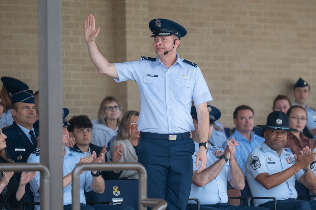 U.S. Air Force Col. Richard Kind, 97th Air Mobility Wing commander, waves to the crowd during the Basic Military Training graduation parade at Joint Base San Antonio-Lackland, Texas, April 2, 2026. The visit to the 37th Training Wing gave Altus leaders the opportunity to not only witness the resilience and professionalism of new Airmen, but encourage and congratulate them as they begin the next phase of their Air Force careers. (U.S. Air Force photo by Airman 1st Class Emma Wright)