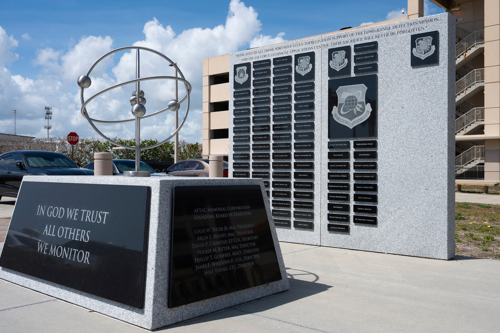 The Air Force Technical Applications Center at Patrick Space Force Base, Fla., added four names to its Memorial Wall that stands outside the center’s headquarters during a ceremony April 3, 2026.   The memorial consists of a 15-foot square concrete pad that holds two granite wall segments displaying the names of the fallen, and two stone benches to give visitors a peaceful place for moments of reflection. Immediately in front of the wall is a brushed steel lithium ion atop a granite pedestal, and leading up to the monument is a bricked walkway that contains inscribed dedication stones (U.S. Air Force photo by Susan A. Romano)