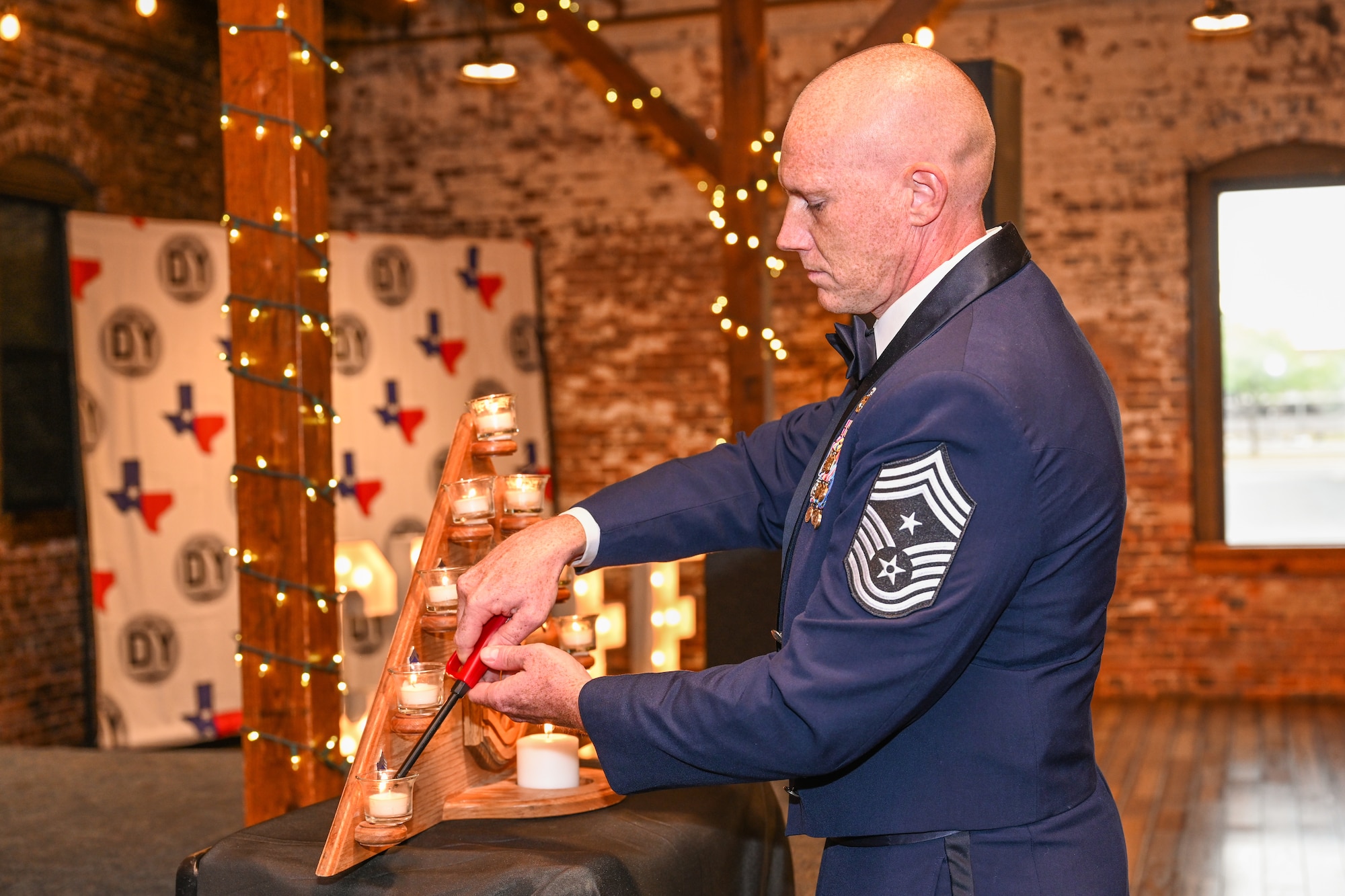 U.S. Air Force Chief Master Sgt. Benjamin McCullough, 7th Bomb Wing command chief, lights the Chief’s Candle during a Chief Master Sergeant Induction Ceremony in Abilene, Texas, March 28, 2026. The candle lighting symbolizes the inductees’ journey from airman basic to the rank of chief master sergeant. (U.S. Air Force photo by Airman 1st Class Caleb Schellenberg)
