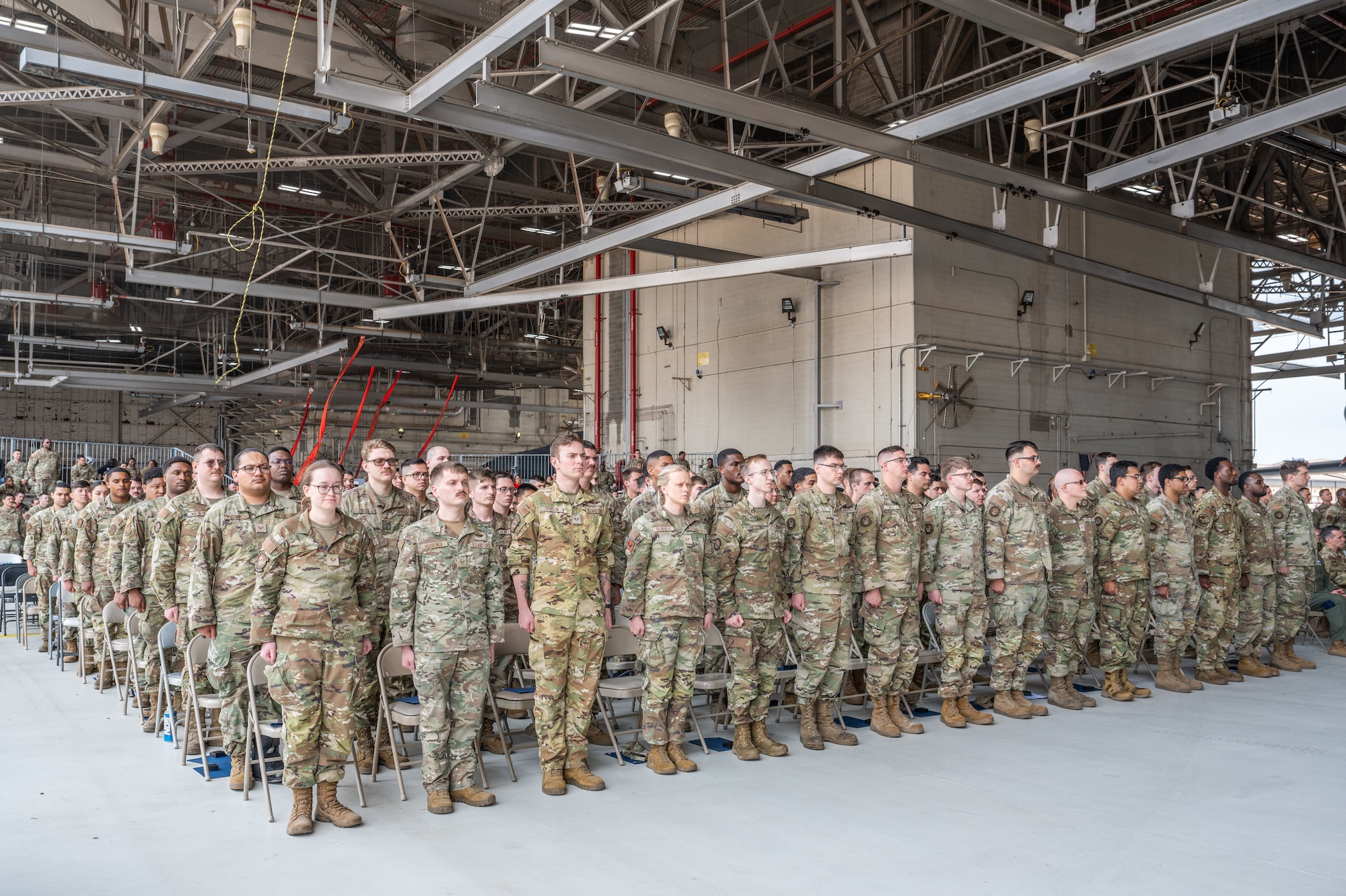 U.S. Airmen assigned to the 7th Bomb Wing and 317th Airlift Wing stand at attention during a Noncommissioned Officer Induction Ceremony at Dyess Air Force Base, Texas, April 3, 2026. During the ceremony, inductees accepted the NCO charge, which entrusts them to balance mission accomplishment with the professional development and care of Airmen. (U.S. Air Force photo by Airman 1st Class Caleb Schellenberg)
