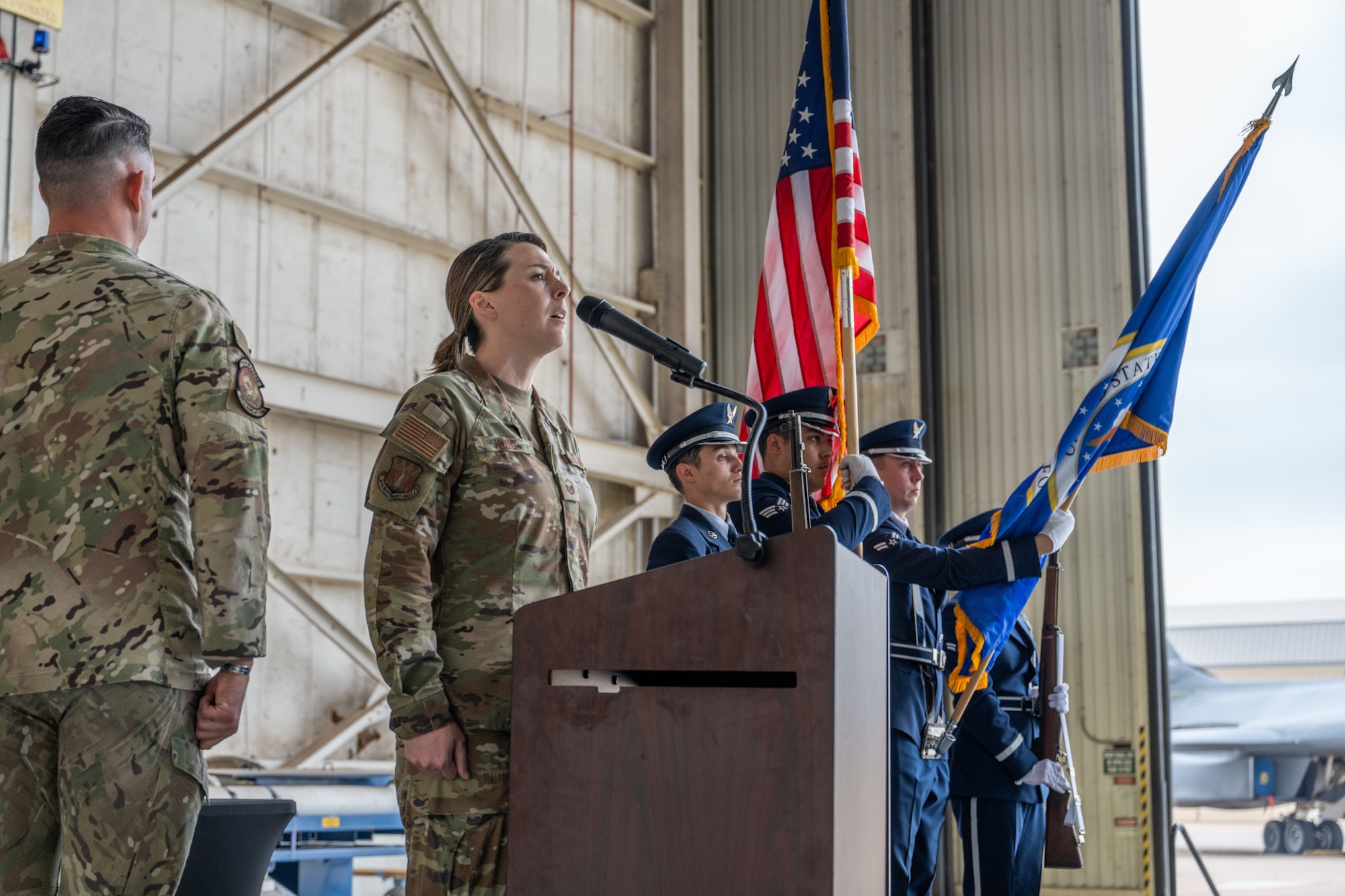 U.S. Air Force Master Sgt. Trisha King, 317th Maintenance Group resource advisor, sings the national anthem during a Noncommissioned Officer Induction Ceremony at Dyess Air Force Base, Texas, April 3, 2026.  The ceremony highlighted the Airmen’s transition to increased leadership responsibilities within the NCO corps. (U.S. Air Force photo by Airman 1st Class Caleb Schellenberg)