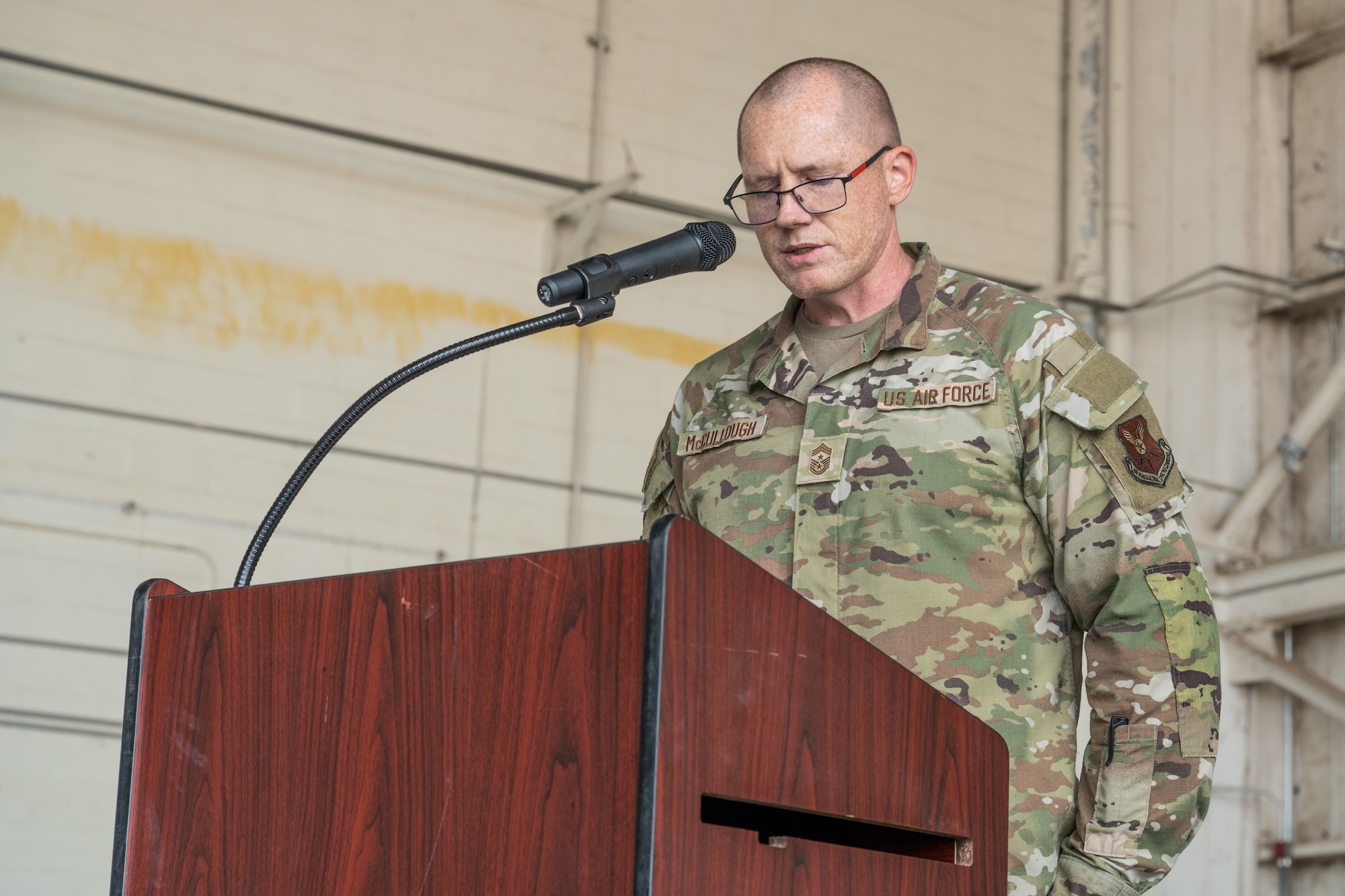 U.S. Air Force Chief Master Sgt. Benjamin McCullough, 7th Bomb Wing command chief, reads the noncommissioned officer charge during an NCO Induction Ceremony at Dyess Air Force Base, Texas, April 3, 2026.  The NCO charge entrusts inductees to balance mission accomplishment with the professional development and care of Airmen. (U.S. Air Force photo by Airman 1st Class Caleb Schellenberg)