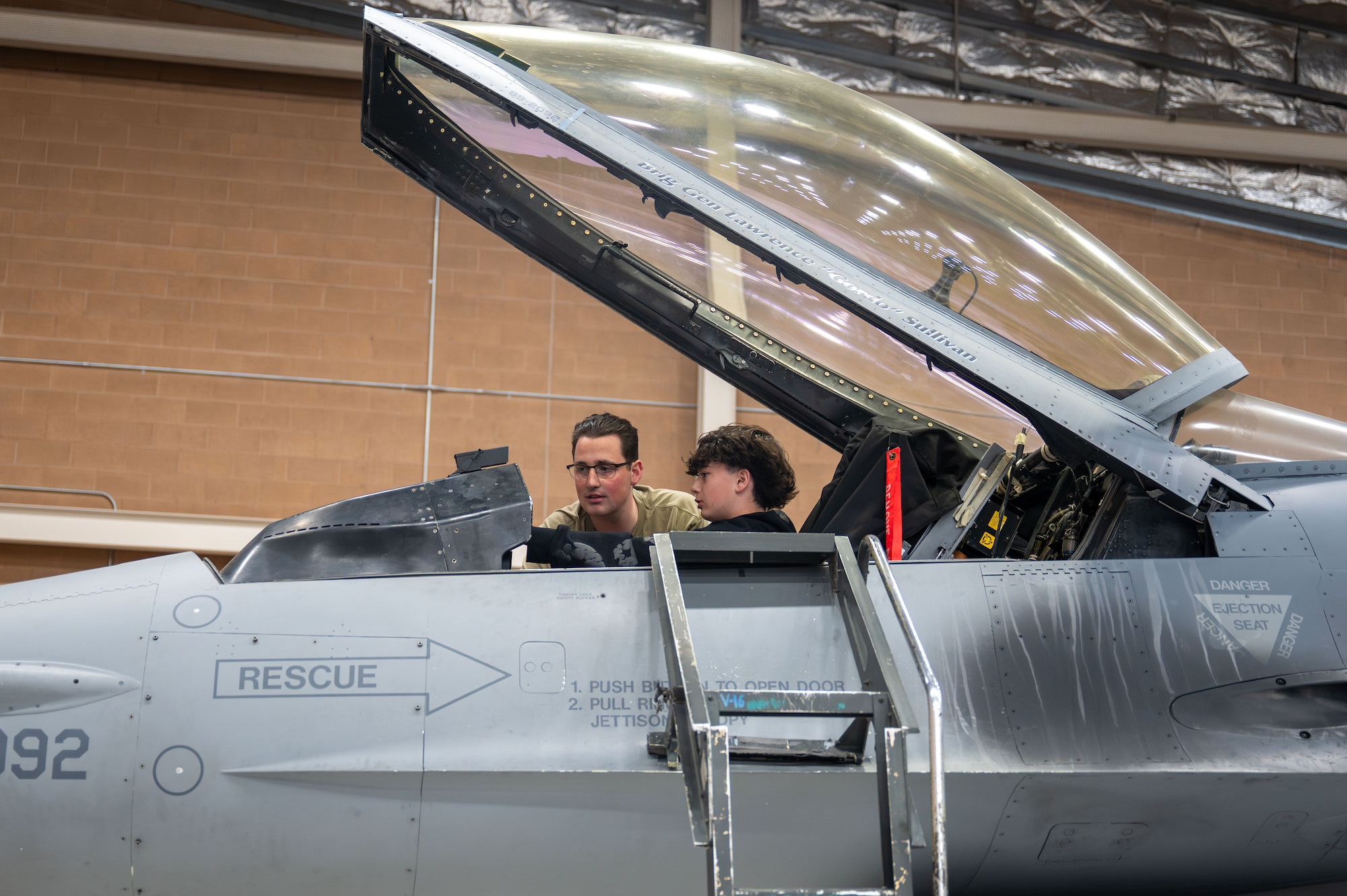 Airman shows foster teen an F-16 Fighting Falcon Cockpit