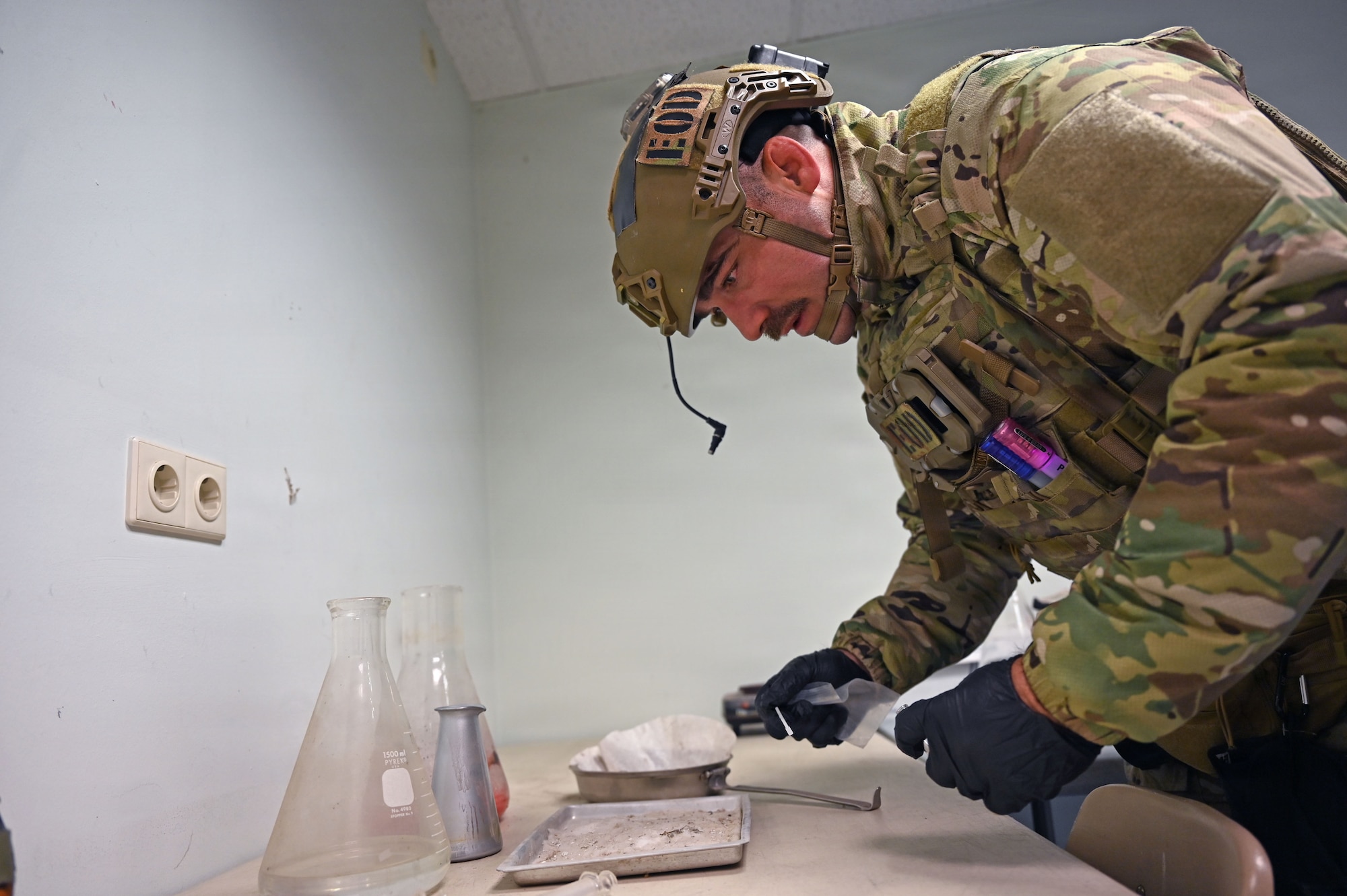 A military member collects a sample