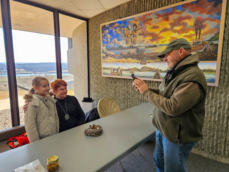 People taking picture with small snake.