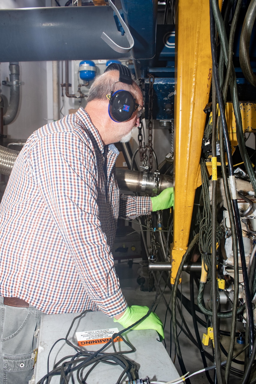 Anthony Jones, an artisan in the Fleet Readiness Center East Engine Driven Compressor and Gas Turbine Compressor Shop, connects a C-2A Greyhound auxiliary power unit to a test stand in order to check the component’s functionality.