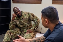 Servicemember and health care professional sitting in an office discussing information related to mental health.