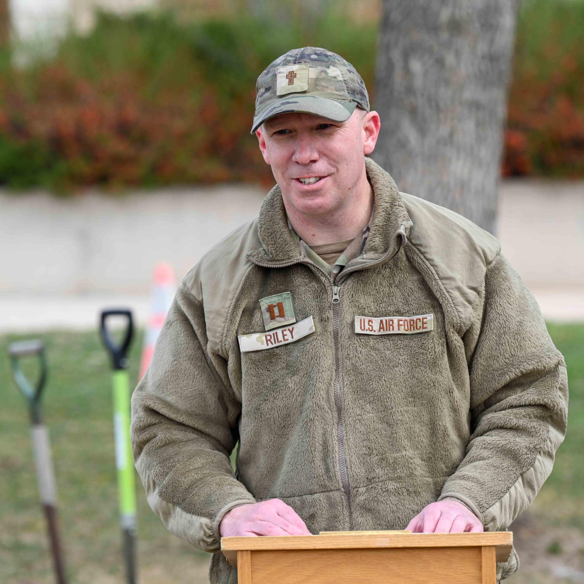 U.S. Air Force Capt. Benjamin Riley, stands behind a podium while addressing an audience.