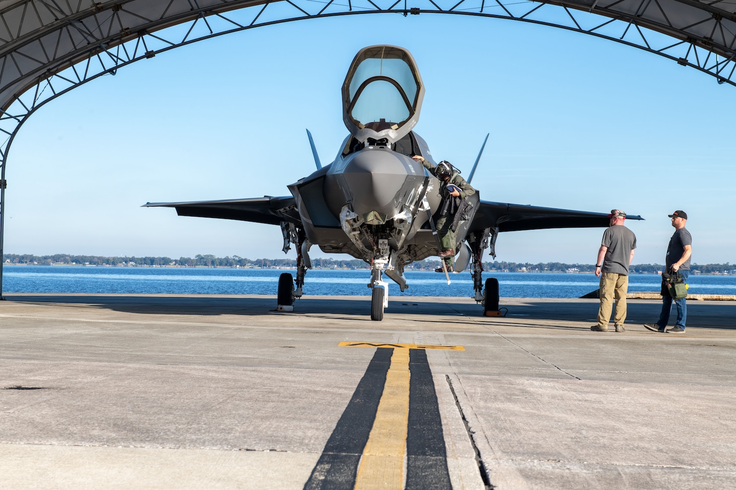 A Royal Navy (RN) F-35 Lightning II pilot debarks the aircraft after arriving at Fleet Readiness Center Southeast (FRCSE). The fifth-generation fighter is one of three aircraft from the RN that will undergo a Production Asset Inspection Requirement Tier II (PAIR II) corrosion-mitigation inspection at FRCSE.
