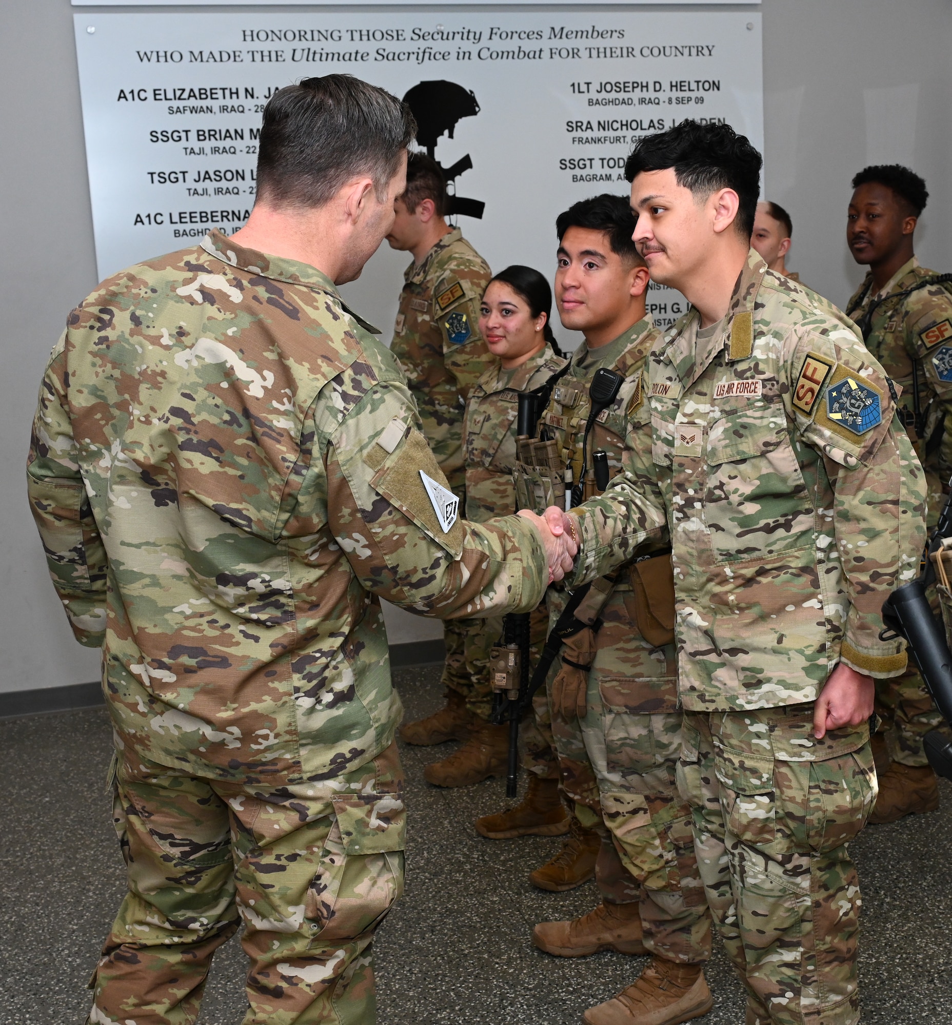 U.S. Space Force Chief Master Sgt. Micheal Rozneck gives a handshake to U.S. Air Force Senior Airman Jean-Mariequy Polon.