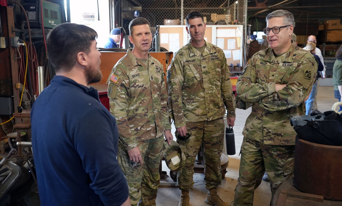 Three Soldiers talking to a machinist