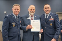 (from left to right) U.S. Air Force Col. Jimmy Schlabach, Mayor Mark Jantzer and U.S. Air Force Col. Jesse W. Lamarand pose for a photo with the signed  Month of the Military Child proclamation.