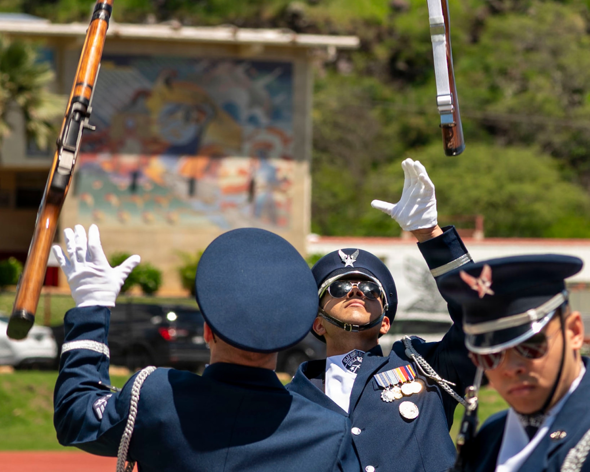 U.S. Air Force Senior Airman Wijeury Collado, U.S. Air Force Honor Guard Ceremonial Guardsman, exchanges rifles in an overhead toss during a performance in Kalani, Hawaii, April 1, 2026. The U.S. Air Force Honor Guard Drill Team performed for the Coast Guard Junior Reserve Officer Training Corps at Kalani High School, one of 16 Coast Guard JROTC units in the U.S. (U.S. Air Force photo by Staff Sgt. Jordan Powell)