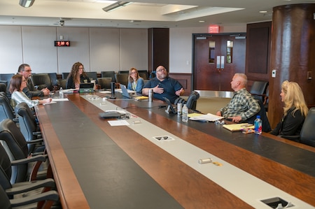Photo of some members of our safety team and the safety auditors sitting around a table.