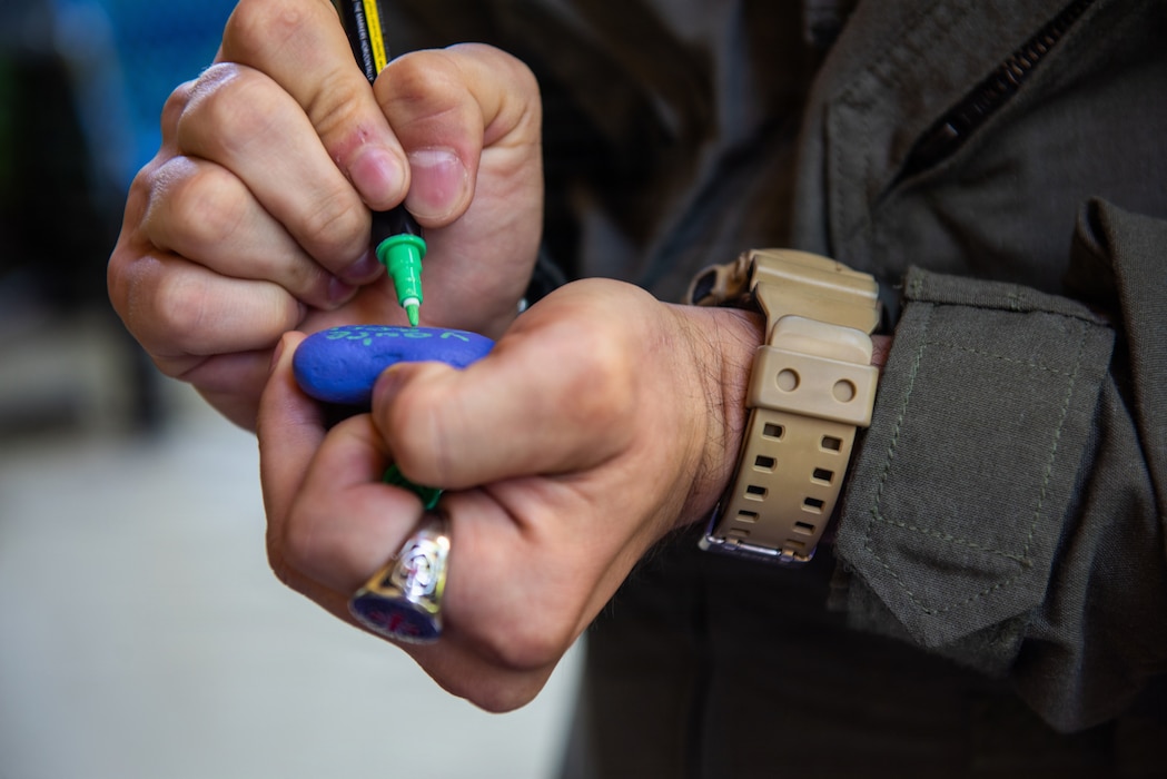 Cadet decorates a stone during tour